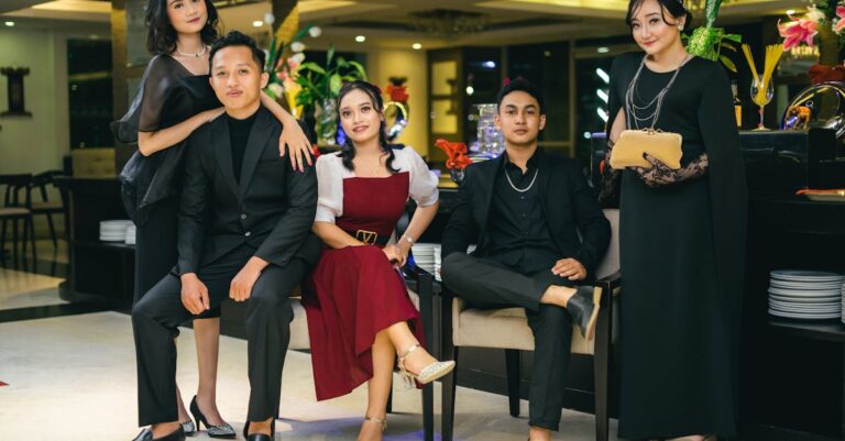 Stylish group of young adults in formal attire posing indoors at a classy event.