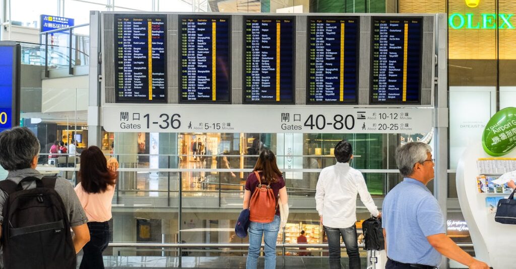 Passengers checking the departure board at Hong Kong International Airport terminal.