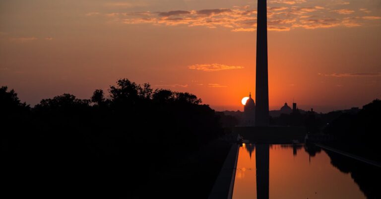 Captivating sunrise silhouette of the Washington Monument and reflection pool in Washington DC.