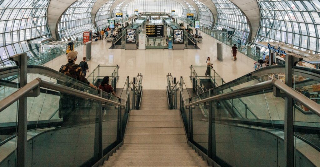 Spacious modern airport terminal featuring a glass dome design and descending stairway view.