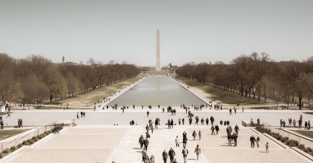A crowd enjoys a sunny day at the Washington Monument Reflection Pool, a popular tourist spot in Washington, D.C.
