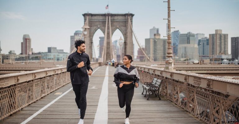 A couple jogging and enjoying fitness on the iconic Brooklyn Bridge in New York City.