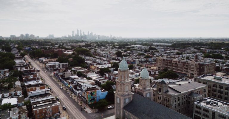 Aerial view showcasing Philadelphia's skyline and urban landscape with a historic church in the foreground.