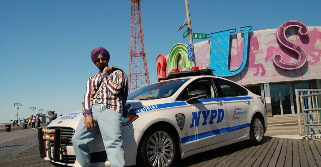 Unveiling the Luxury of Black Car Everywhere Limousine & Car Service: #1 JetBlack Transportations 2 A stylish man in sunglasses poses by a police car at Coney Island, NYC.