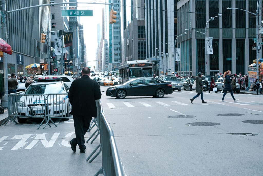 Black sedan on a New York City avenue, daytime