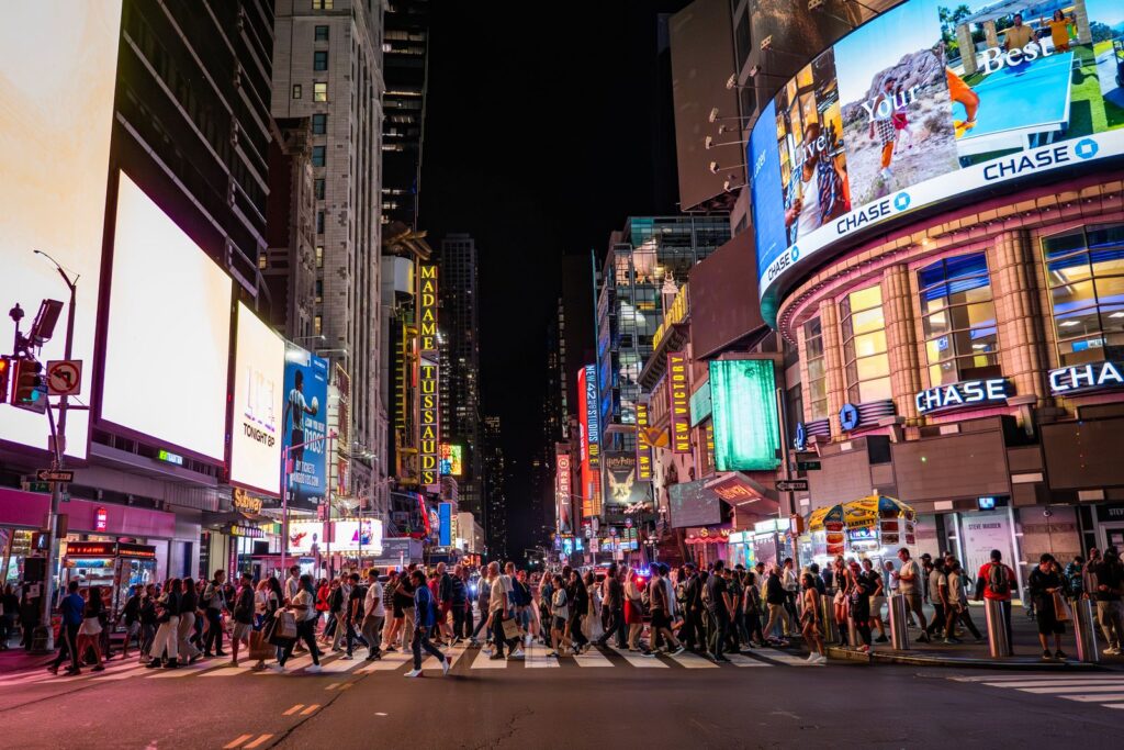 Times Square at night in New York City with bustling crowds and bright billboards